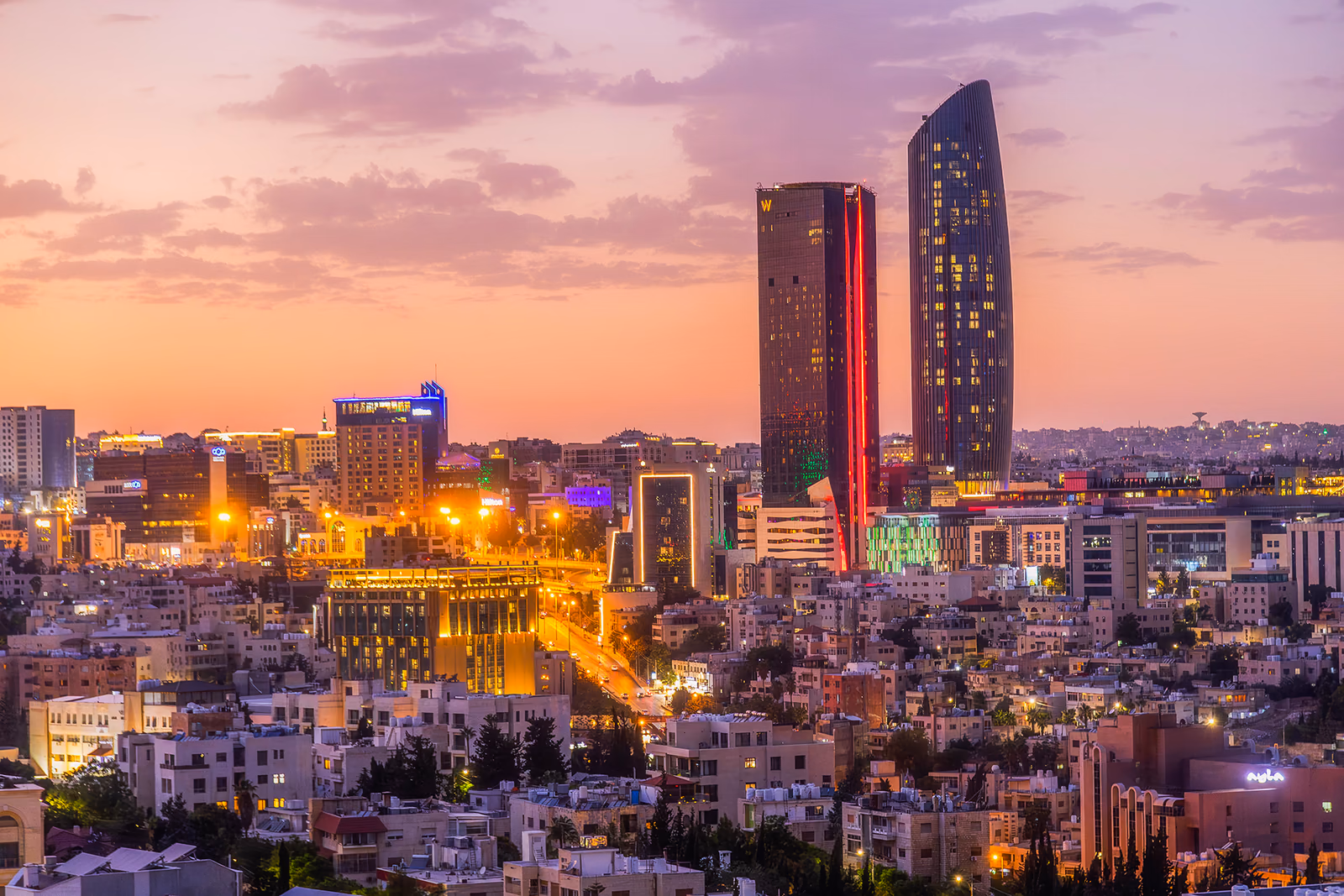 أفق مدينة عمّان الأبيض وتلالها الحجرية عند الغروب، الأردن